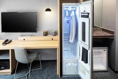 a refrigerator in a room with a desk and a tv at Henn na Hotel New York in New York