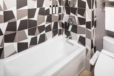a bathroom with a black and white checkered wall at Henn na Hotel New York in New York