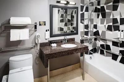 a bathroom with a sink and a tub and a toilet at Henn na Hotel New York in New York