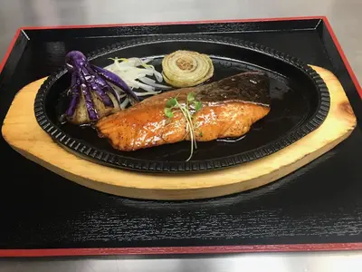 a black plate of food with fish and vegetables at Henn na Hotel New York in New York
