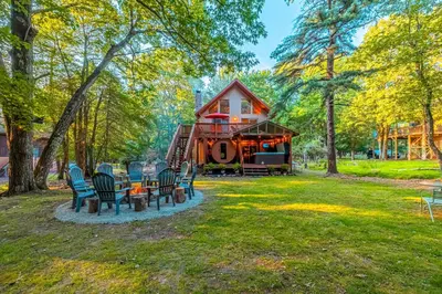 a group of chairs sitting in front of a house at 3 Mi to Slopes! Poconos Chalet with Hot Tub and Sauna in Lake Harmony