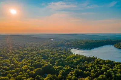 an aerial view of a river and forest at sunset at 3 Mi to Slopes! Poconos Chalet with Hot Tub and Sauna in Lake Harmony