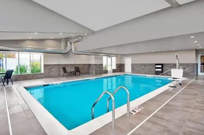 a large swimming pool with blue water in a building at Residence Inn by Marriott Reading in Wyomissing