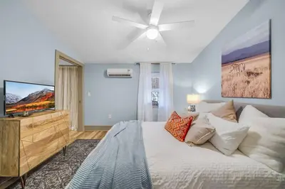 a bedroom with a bed and a flat screen tv at Luxury Apartment in Historic Carriage House in Kennett Square