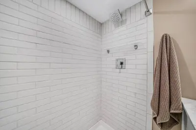 a bathroom with a shower with white tiles at Luxury Apartment in Historic Carriage House in Kennett Square