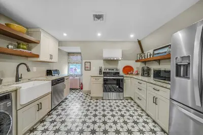 a kitchen with white appliances and a tile floor at Luxury Loft in Historic Carriage House in Kennett Square