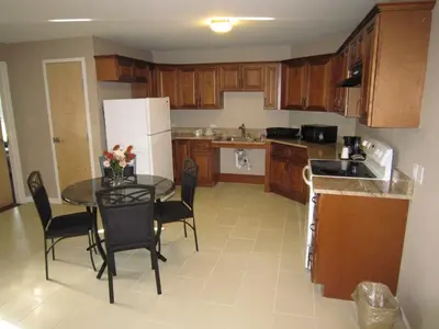 a kitchen with a table and chairs in a kitchen at Red Carpet Inn and Suites Monmouth Junction in Monmouth Junction