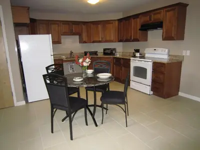 a kitchen with a table with chairs and a refrigerator at Red Carpet Inn and Suites Monmouth Junction in Monmouth Junction