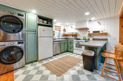 a kitchen with green cabinets and a washer and dryer at Hilltop Walton Getaway with Picturesque Views! in Walton