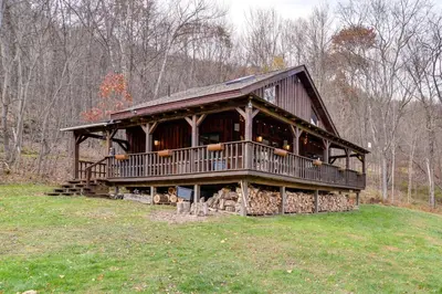 a large wooden cabin in the middle of a field at Hilltop Walton Getaway with Picturesque Views! in Walton