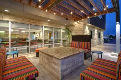 a patio with a bar with chairs and tables at Home2 Suites East Hanover, NJ in East Hanover