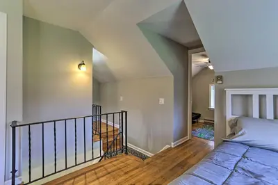a bedroom with a bed next to a staircase at Patio and Fire Pit Idyllic Cottage in Hellertown! in Bethlehem