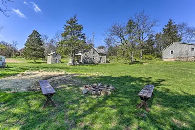 two benches sitting next to a fire in a field at Patio and Fire Pit Idyllic Cottage in Hellertown! in Bethlehem