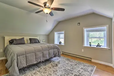 a bedroom with a ceiling fan and two windows at Patio and Fire Pit Idyllic Cottage in Hellertown! in Bethlehem