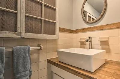 a bathroom with a white sink and a mirror at Patio and Fire Pit Idyllic Cottage in Hellertown! in Bethlehem