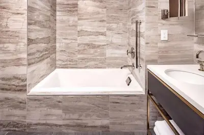 a bathroom with a tub and a sink at Hilton Club The Central at 5th New York in New York