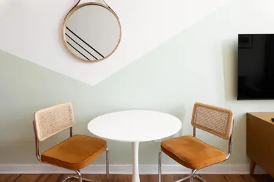 a white table with two chairs and a mirror at Sosuite at West Lofts - West Philadelphia in Philadelphia