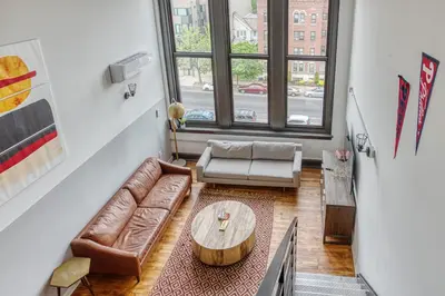 a living room with a couch and a table at Sosuite at West Lofts - West Philadelphia in Philadelphia