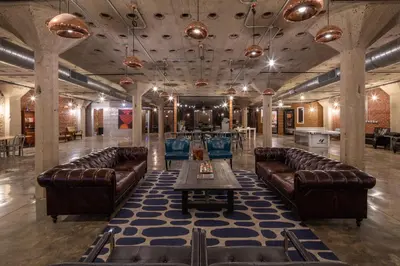 a large room with leather couches and a table in it at Sosuite at West Lofts - West Philadelphia in Philadelphia