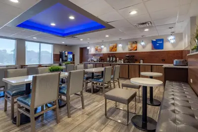 a restaurant with tables and chairs and a bar at MainStay Suites Horsham - Philadelphia in Horsham