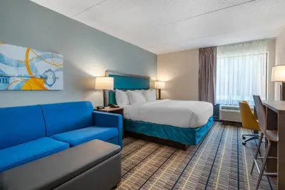 a hotel room with a bed and a blue couch at MainStay Suites Horsham - Philadelphia in Horsham
