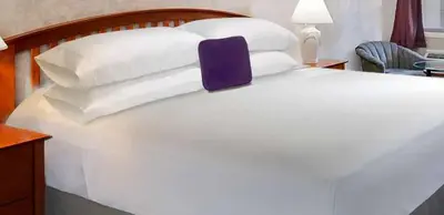 a large white bed with white pillows on it at Knights Inn Center Valley in Center Valley