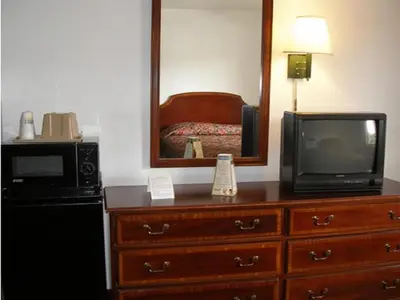 a room with a microwave and a television on a dresser at Knights Inn Center Valley in Center Valley