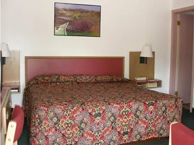 a bedroom with a large bed with a red head board at Knights Inn Center Valley in Center Valley