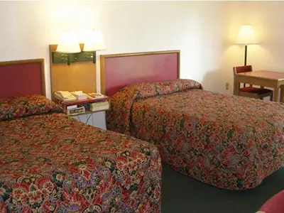 a hotel room with two beds and a table at Knights Inn Center Valley in Center Valley