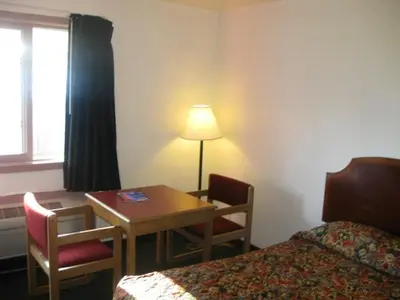 a hotel room with a desk and a table and a bed at Knights Inn Center Valley in Center Valley