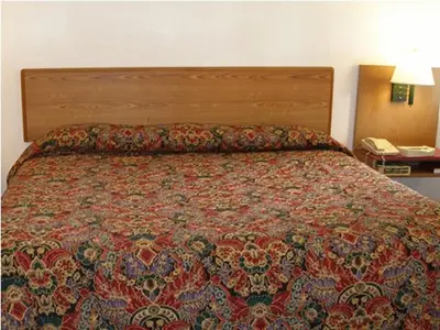 a bed in a hotel room with a patterned bedspread at Knights Inn Center Valley in Center Valley