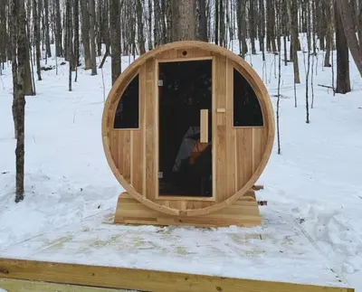 a wooden cabin with a door in the snow at Cozy Cottage with Jacuzzi, Sauna, Fire Pit and Reading Nook! in Livingston Manor
