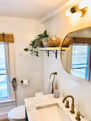 a bathroom with a sink and a mirror at Cozy Cottage with Jacuzzi, Sauna, Fire Pit and Reading Nook! in Livingston Manor