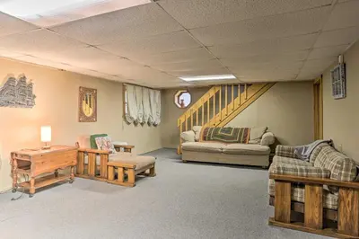 a living room with couches and a stair case at Resort Perks Picturesque Poconos Getaway! in Bushkill