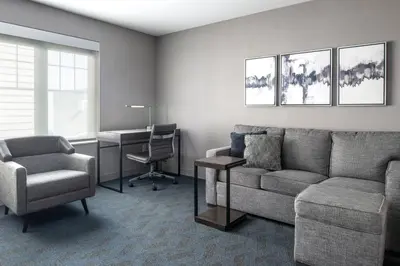 a living room with a couch and a chair and a desk at Residence Inn by Marriott Orangeburg in Orangeburg