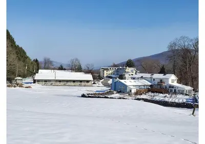 a snow covered yard with houses and buildings in the background at Glenwood Inn - Stroudsburg in Delaware Water Gap