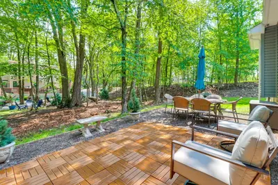 a patio with a table and chairs and an umbrella at 7 Mi to Camelback Mtn Chic Penn Estates Home in East Stroudsburg