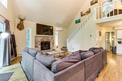 a living room with a large couch and a fireplace at Furnished Deck and Fire Pit Poconos Outdoorsy Gem in Albrightsville