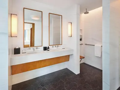 a bathroom with two sinks and two mirrors at Pendry Manhattan West in New York