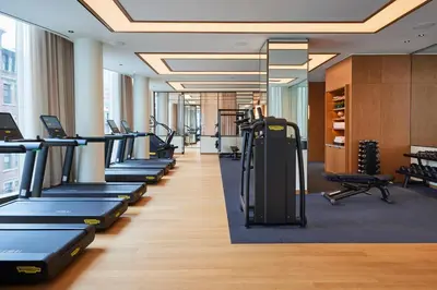 a gym with rows of treadmills and exercise equipment at Pendry Manhattan West in New York