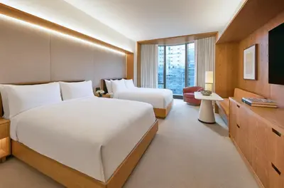 a hotel room with two beds and a television at Pendry Manhattan West in New York