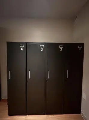 three black lockers are lined up in a room at Nap York Central Park Sleep Station in New York