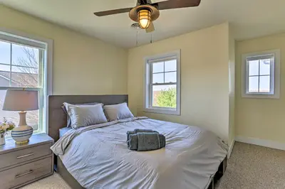 a bedroom with a bed with a ceiling fan and two windows at New ! Slopeside Townhome : WFH, Ski, Dine & Hike in Tannersville