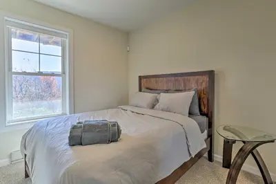 a bedroom with a large bed with a chair and a window at New ! Slopeside Townhome : WFH, Ski, Dine & Hike in Tannersville