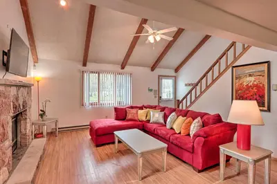 a living room with a red couch and a fireplace at 7 Mi to Big Boulder Mountain Poconos Escape! in Albrightsville