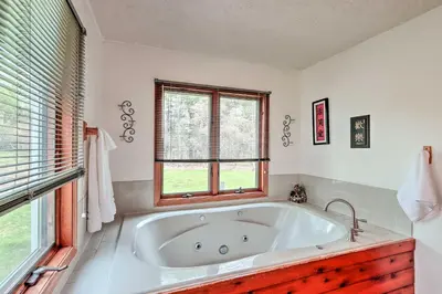 a large white tub in a bathroom with windows at 7 Mi to Big Boulder Mountain Poconos Escape! in Albrightsville
