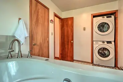 a bathroom with a tub and a washer and dryer at 7 Mi to Big Boulder Mountain Poconos Escape! in Albrightsville