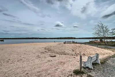 a bench sitting on a sandy beach near the water at 7 Mi to Big Boulder Mountain Poconos Escape! in Albrightsville