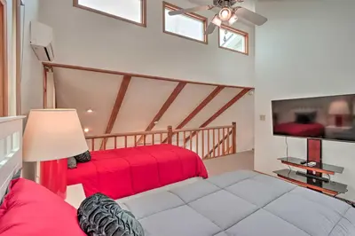 a living room with a red bed and a tv at 7 Mi to Big Boulder Mountain Poconos Escape! in Albrightsville