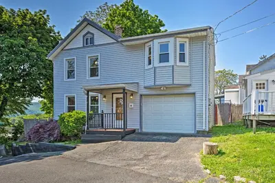 a blue house with a garage in a yard at Updated Home with Patio Half Mile to West Point in Highland Falls